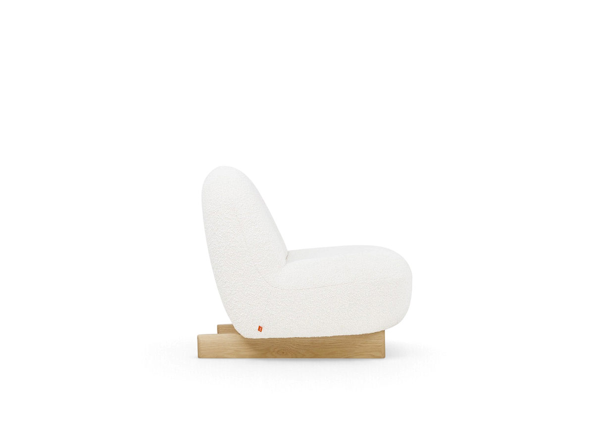 urbane EQ3 Arlo chair in white bouclé fabric with a solid oak sled base, side view showing curved modern design.