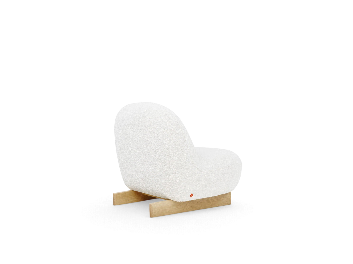 urbane EQ3 Arlo chair in white bouclé fabric with a solid oak sled base, shown from a rear three-quarter angle.