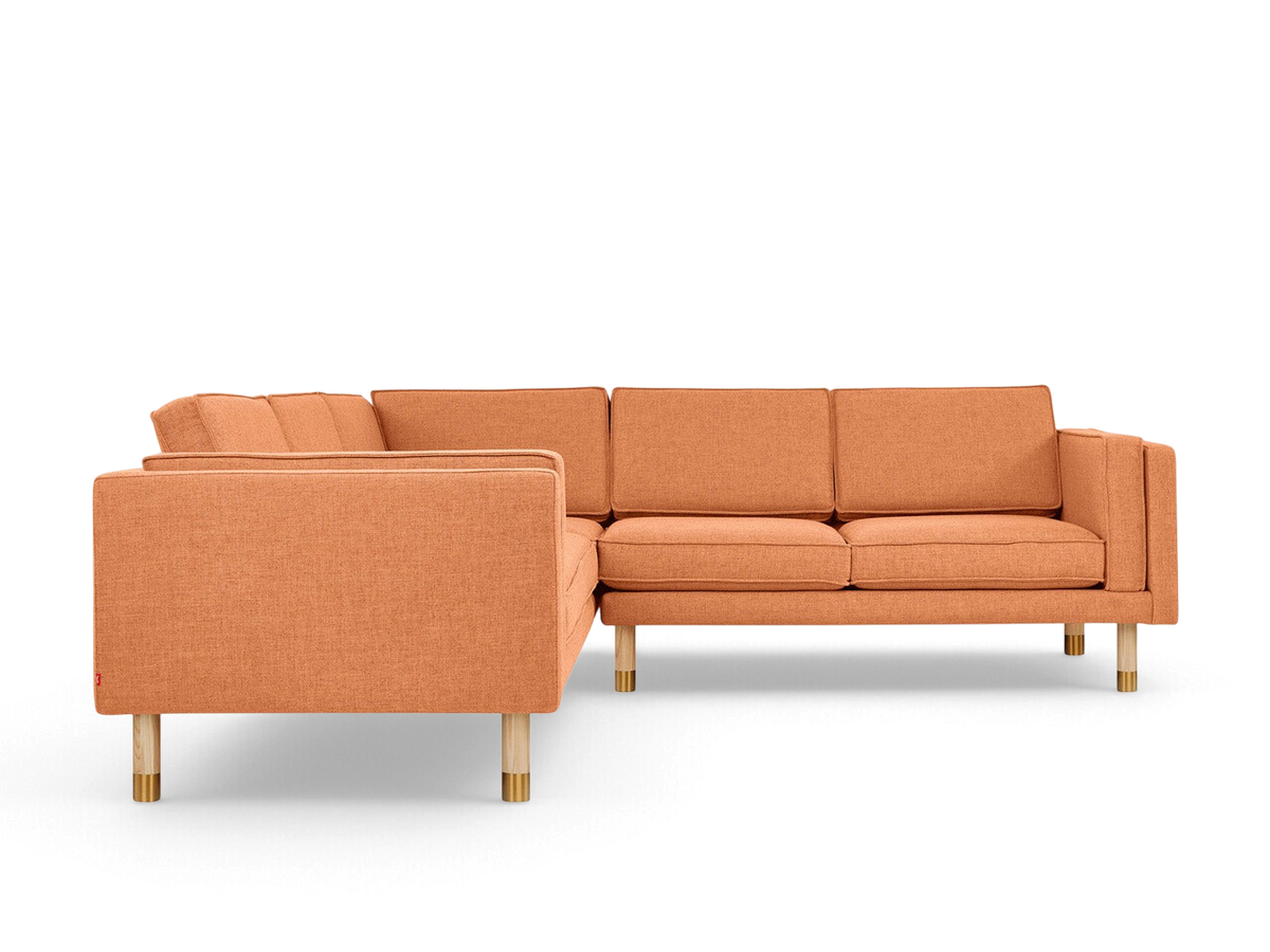 urbane EQ3 Augusta Bi-Sectional in orange fabric with French-seam cushions and natural ash wood legs with brass detail