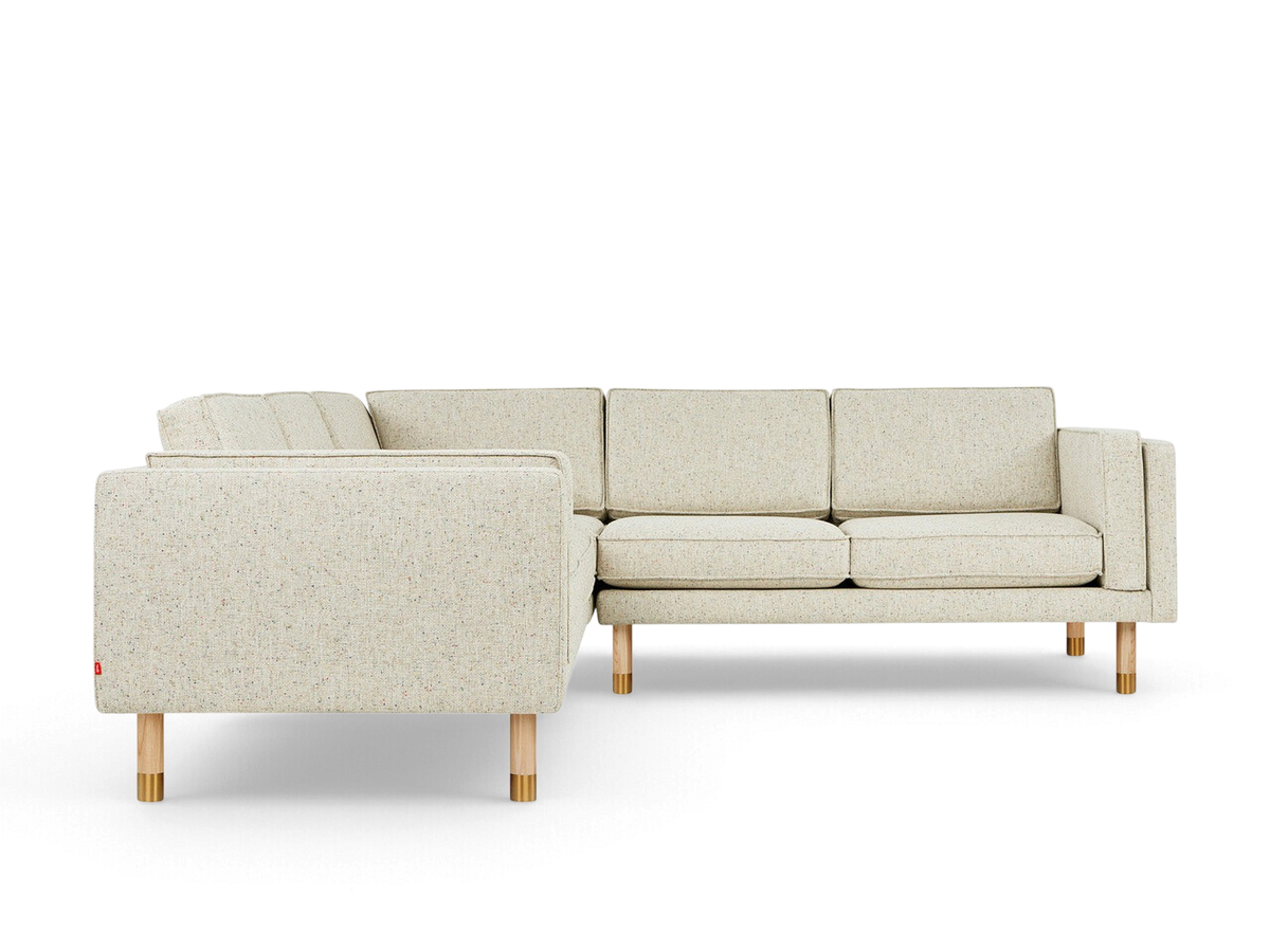 urbane EQ3 Augusta Bi-Sectional in speckled light fabric with natural ash and brass legs on a white background