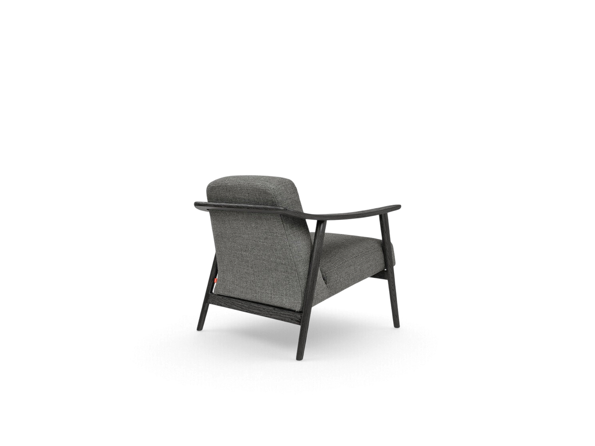 urbane EQ3 Baltic Chair in grey fabric with a dark solid wood frame, showcasing a sculptural back view.
