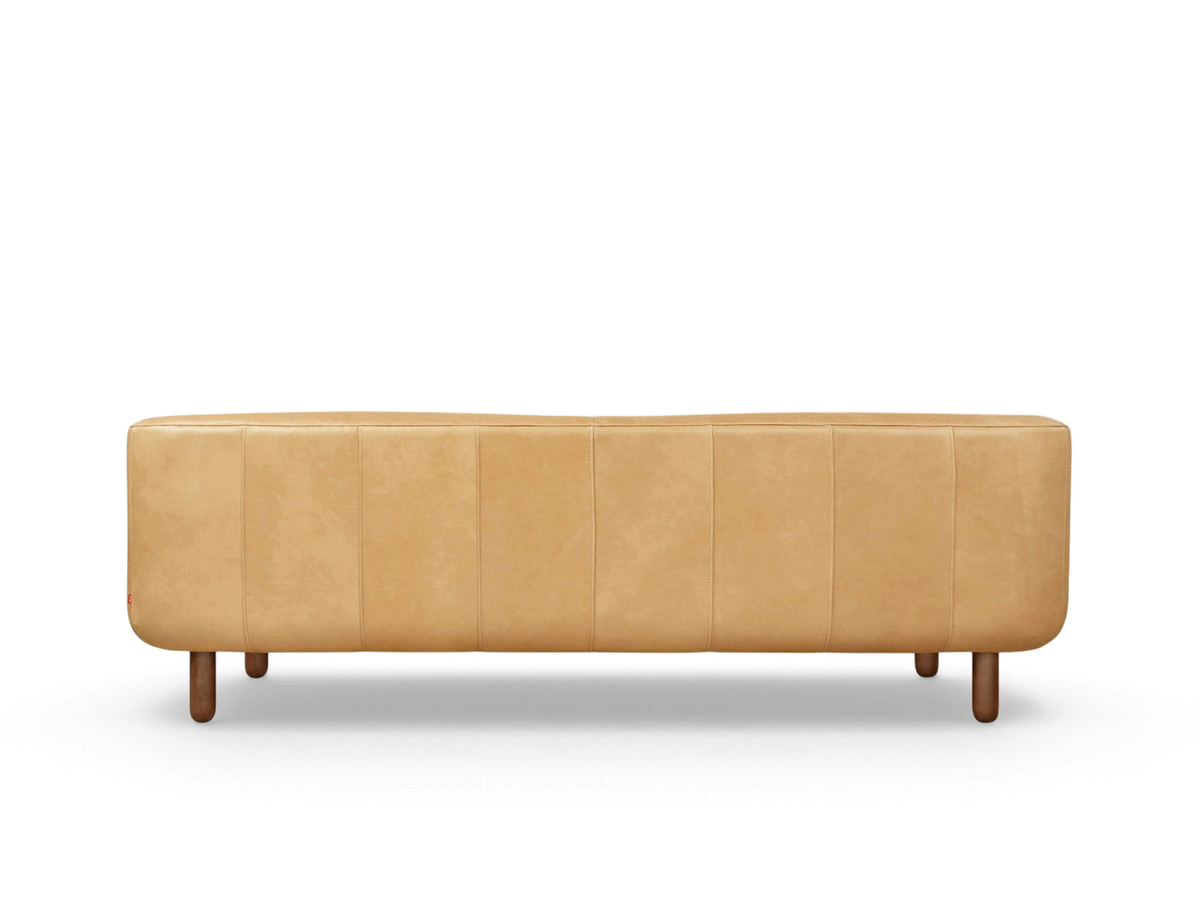 urbane EQ3 Beaconsfield sofa in tan leather with a tuxedo-style frame and walnut stained wood legs, back view.