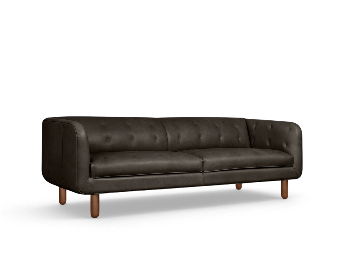 urbane EQ3 Beaconsfield sofa in dark leather with blind-tufted detailing and walnut-stained solid ash wood legs.