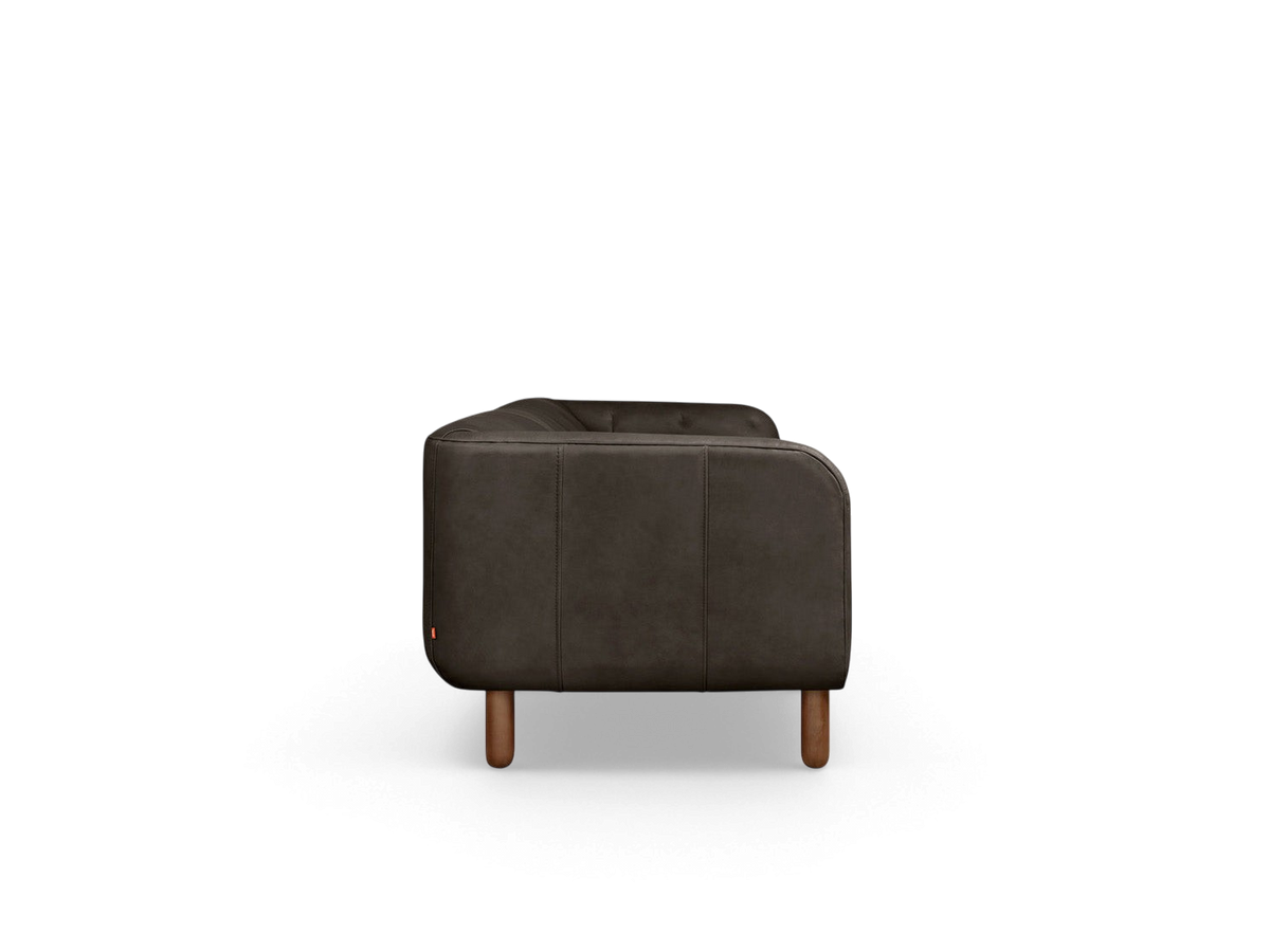 urbane EQ3 Beaconsfield sofa in dark leather with tuxedo-style frame and walnut stained ash wood legs, side view