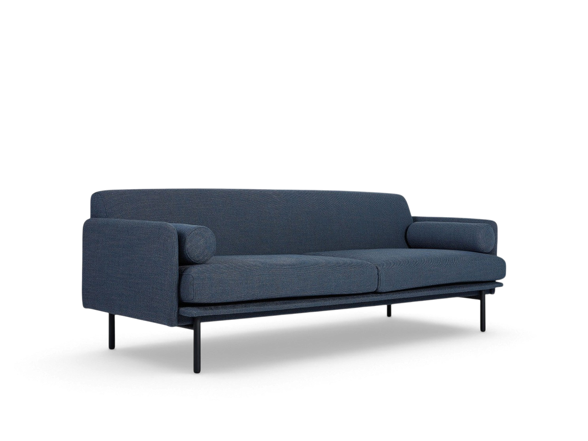 urbane EQ3 Foundry Sofa in blue fabric with a minimalist tightback frame, bolster cushions, and black steel legs.
