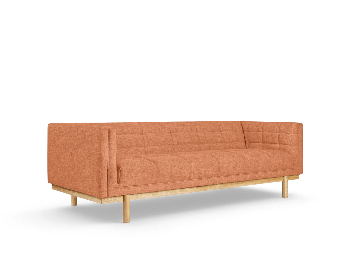 urbane EQ3 Mulholland sofa in burnt orange fabric with blind-tufting and a solid ash wood base on a white background