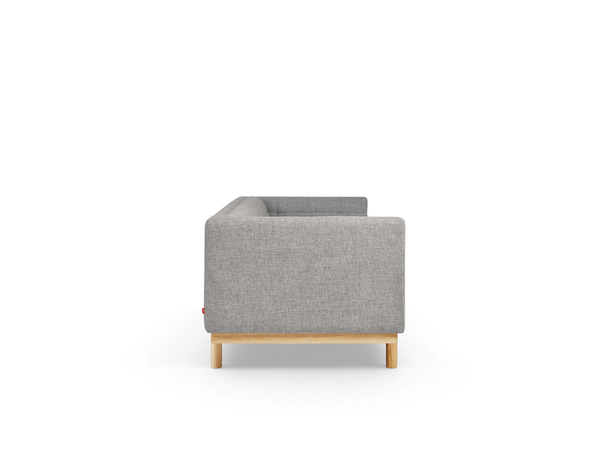 urbane EQ3 Mulholland Sofa side view featuring grey fabric upholstery, tuxedo frame, and solid ash wood base.