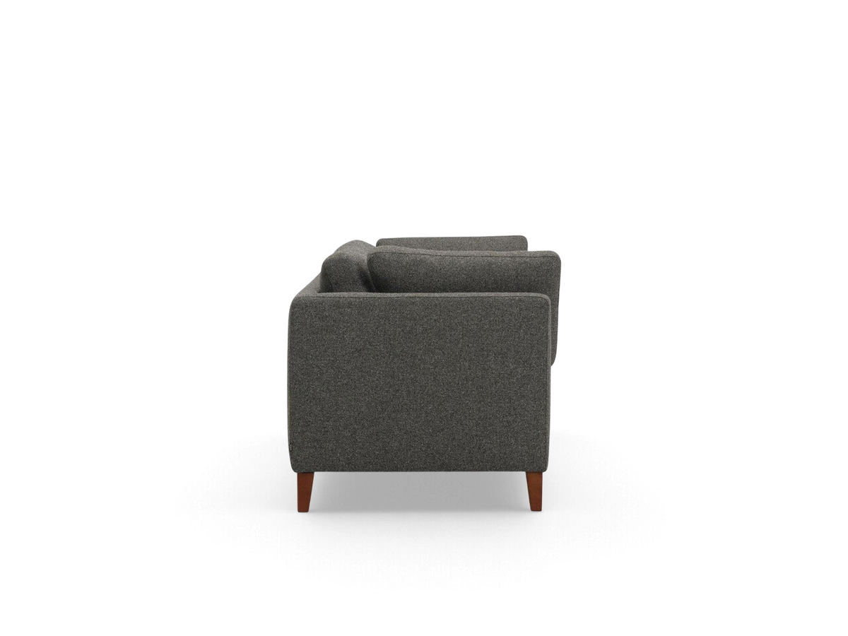 Side view of the urbane EQ3 Salema 87 inch sofa in dark grey fabric with tapered wooden legs
