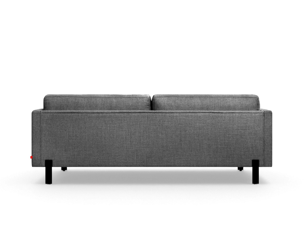 urbane EQ3 Silverlake sofa viewed from the back, featuring a grey textured fabric, tuxedo frame, and black steel legs.