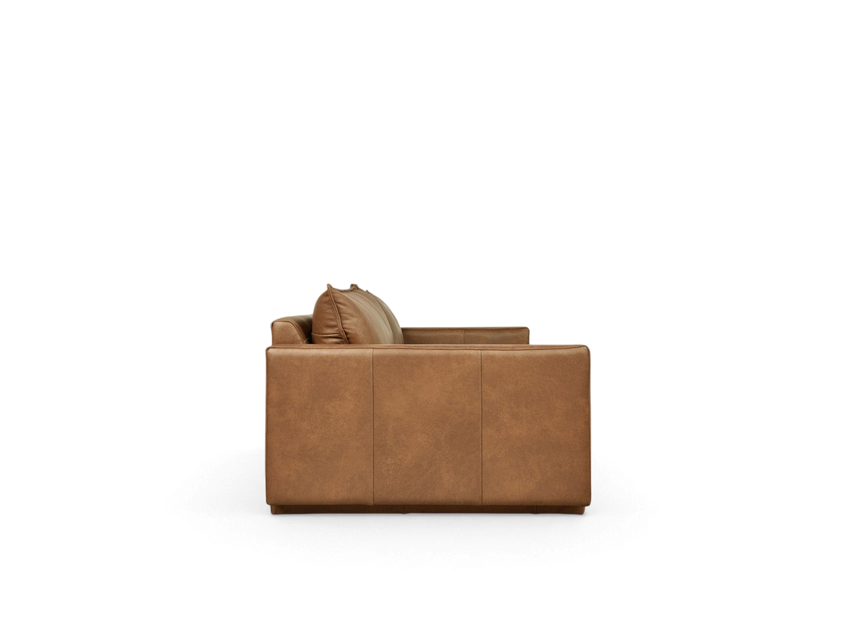Side profile of the urbane EQ3 Sola Sofa featuring tan leather upholstery, French-seam detailing, and stepped arms.