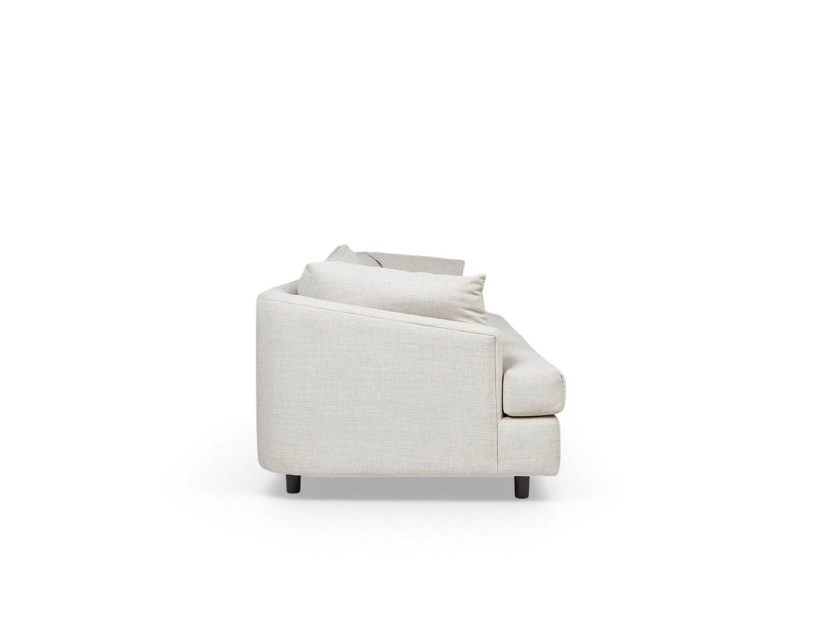 urbane EQ3 Thalia sofa in light beige fabric with a modern wraparound design, side profile view.