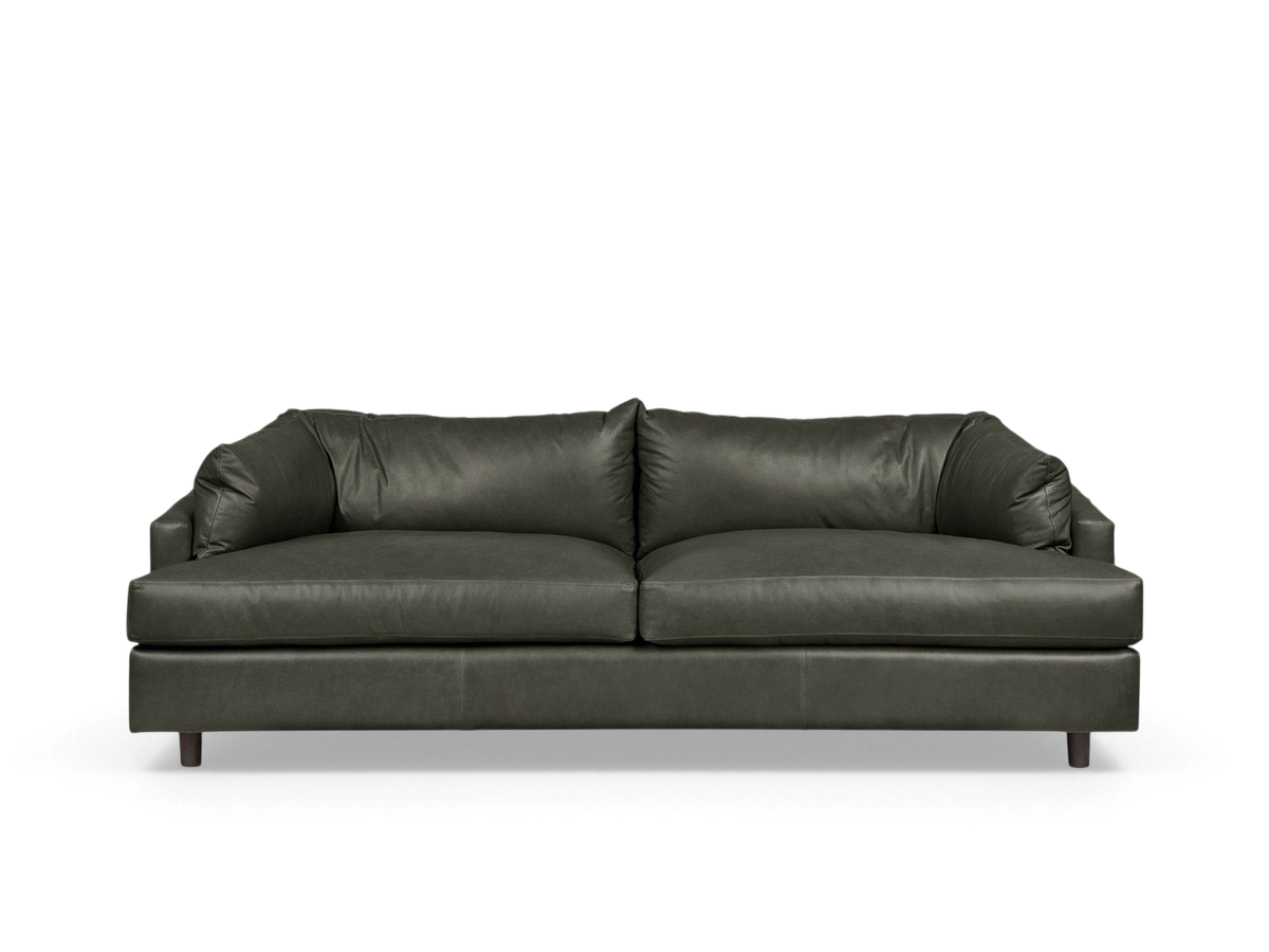 urbane EQ3 Thalia sofa in dark green leather with a 1970s-inspired wraparound cushion design on a neutral background