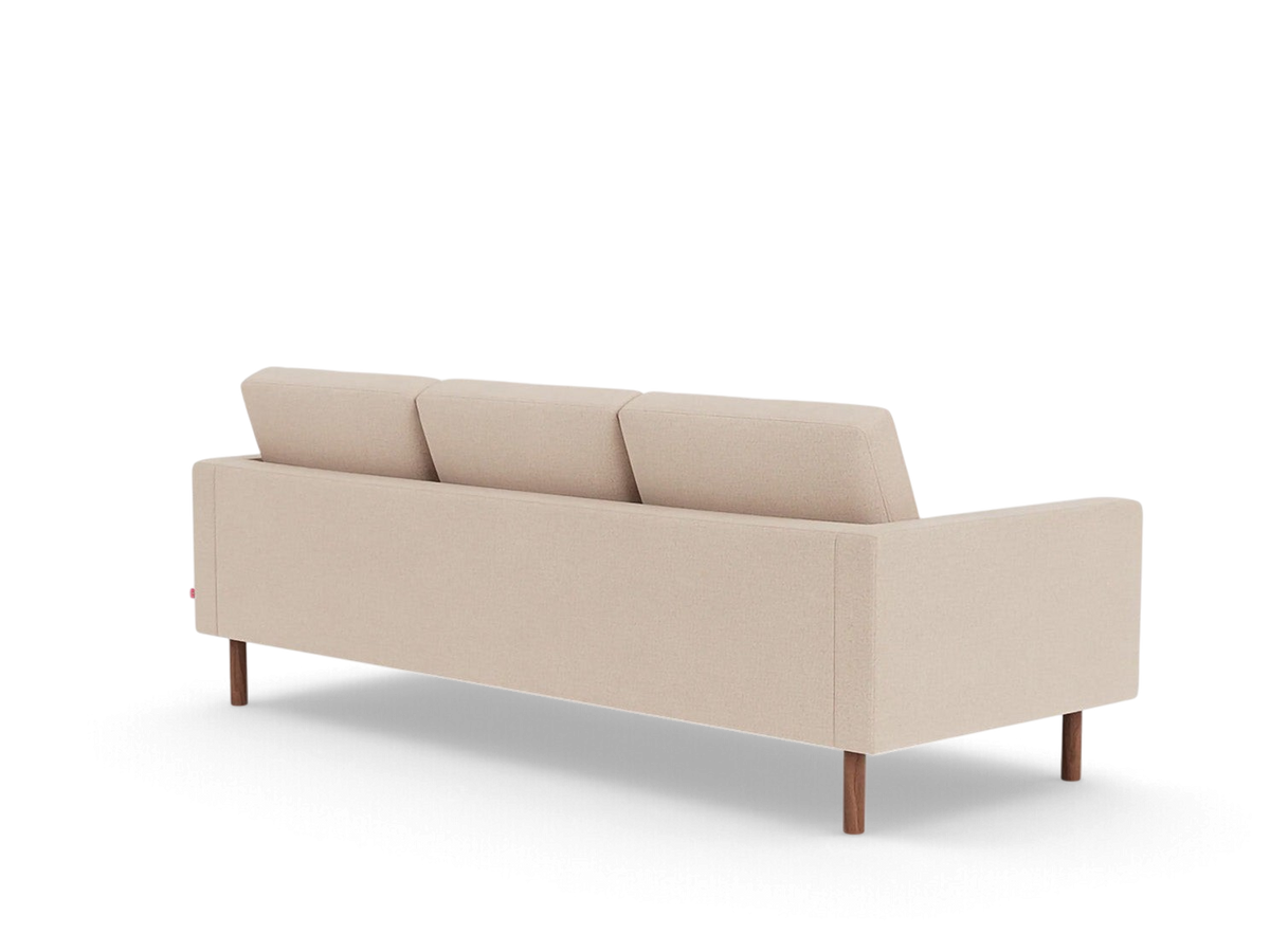 Back view of the urbane EQ3 Joan 87 inch mid-century sofa in beige fabric with dark wooden legs.