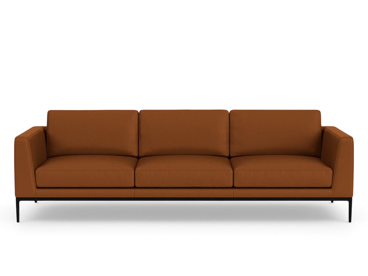 urbane EQ3 Oma 101-inch sofa in cognac leather with a sleek black anthracite metal base and structured cushions.