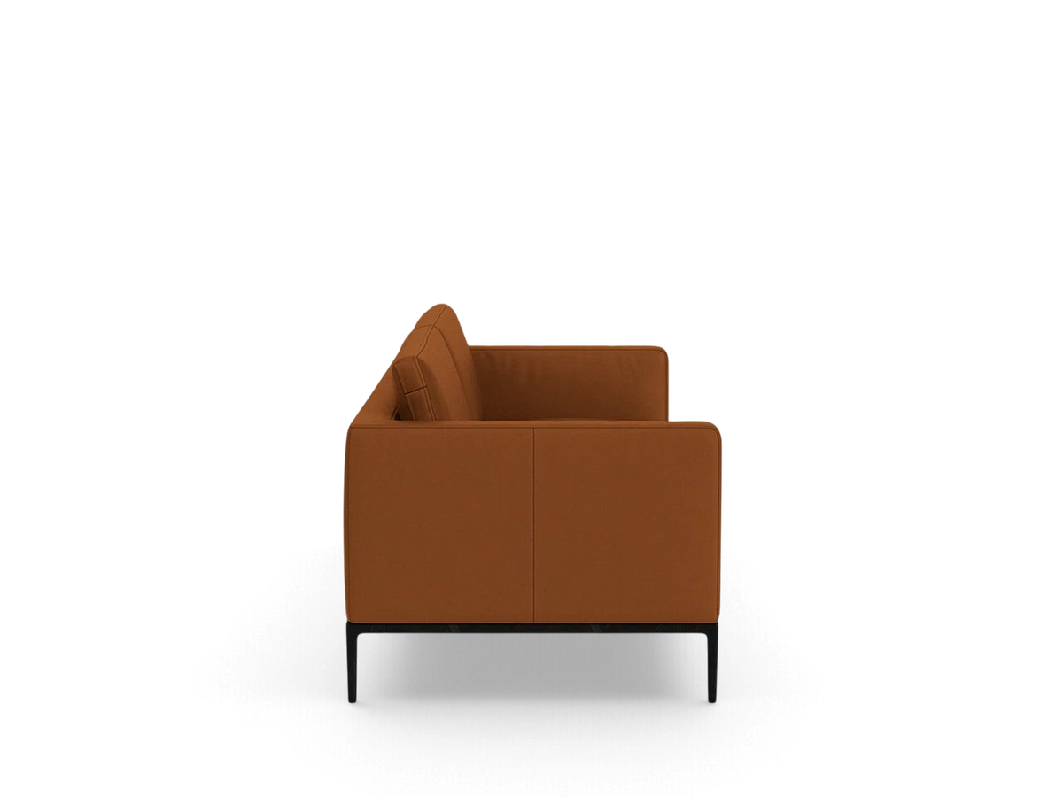 Side view of the urbane EQ3 Oma 89 inch sofa in cognac leather with a sleek black anthracite metal base.