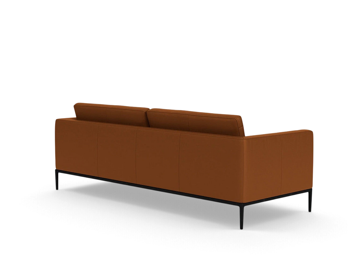 Back view of the urbane EQ3 Oma 89-inch sofa in cognac leather with a sleek black anthracite metal base.
