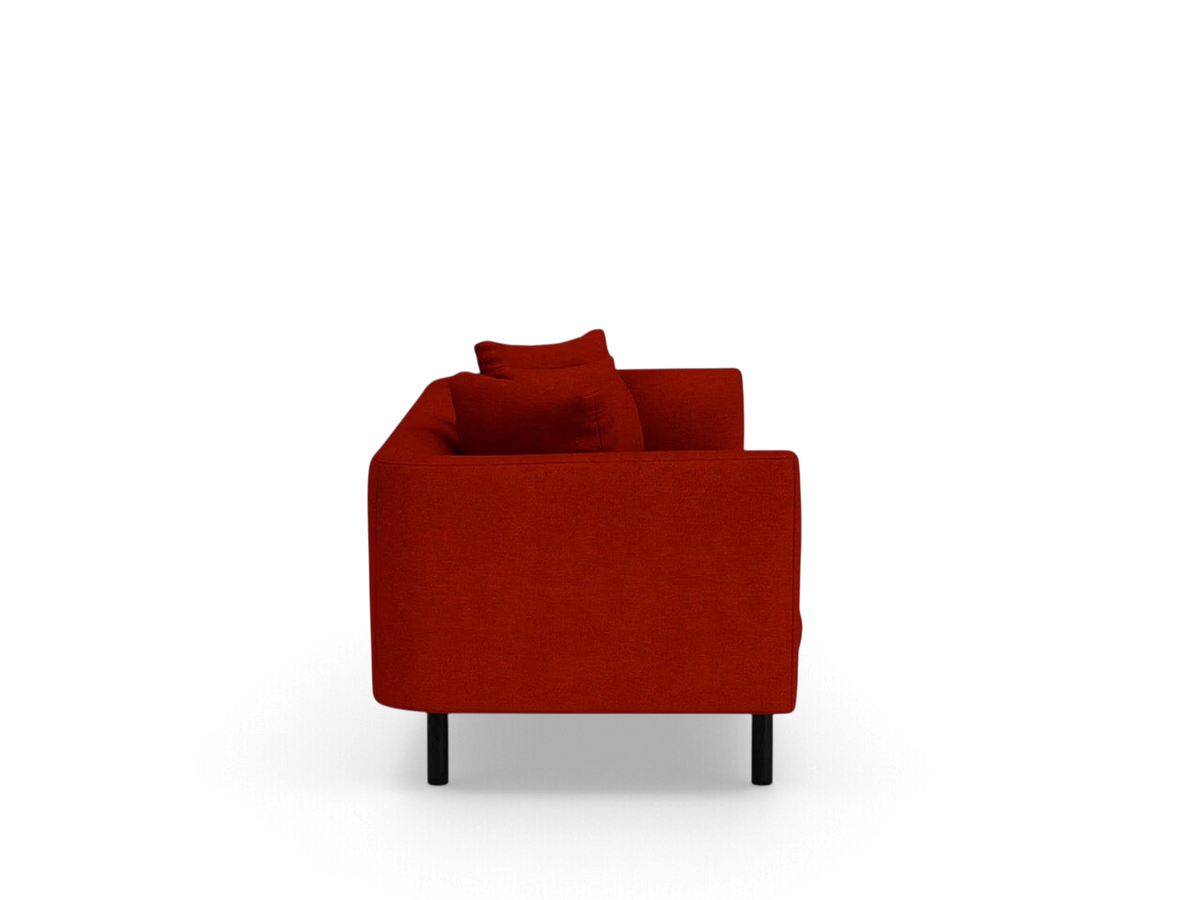 Side view of the red upholstered urbane EQ3 Replay 99 inch sofa with a flexible back frame and black legs.