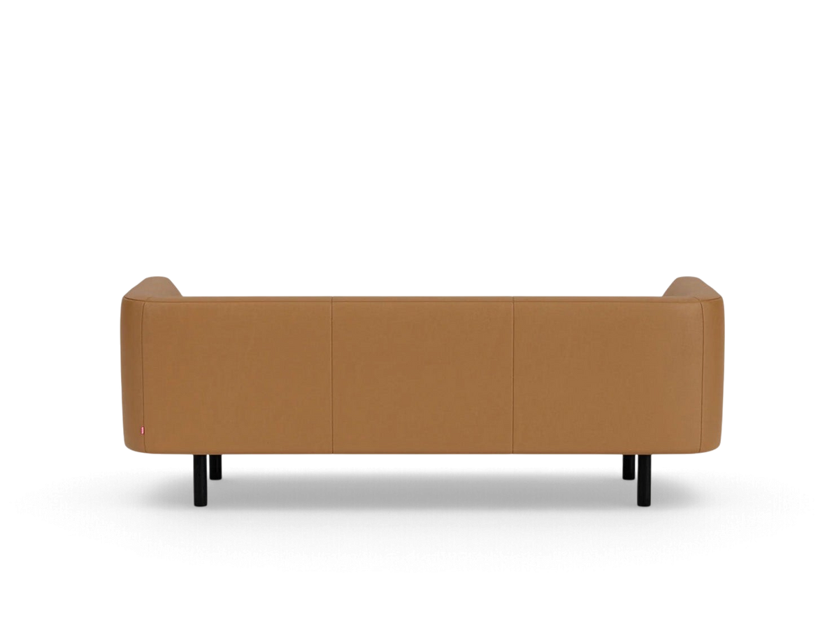 Back view of the tan leather urbane EQ3 Replay Club sofa with black legs against a white background.