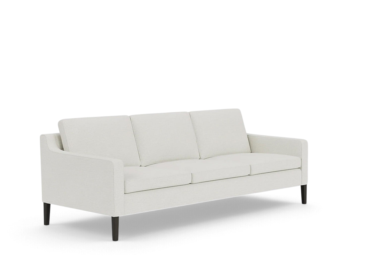 urbane EQ3 Skye sofa in off-white fabric with slim cushions and tapered dark wood legs in a mid-century style